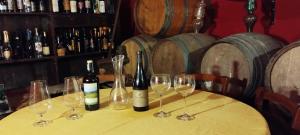 una mesa con botellas de vino y copas. en Al Sangallo Agriturismo, en Montecarlo