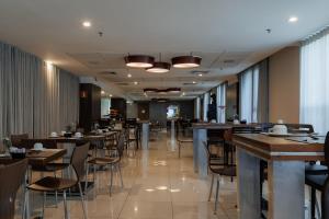 a dining room with tables and chairs in a restaurant at eSuites Belo Horizonte Minascasa in Belo Horizonte