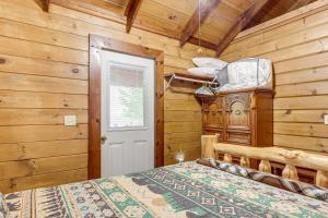 a bedroom with a bed in a room with wooden walls at Cozy Pelsor Cabin with Mountain and Valley Views! 