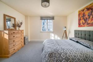 um quarto com uma cama, uma cómoda e um espelho em TruStay Apartments London Bridge em Londres