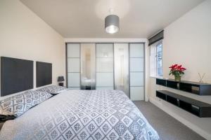 a bedroom with a large bed and a large window at TruStay Apartments London Bridge in London