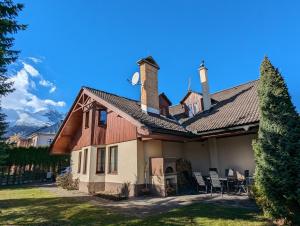 Una casa con dos chimeneas encima. en Vila Art Tatranská Lomnica, en Tatranská Lomnica