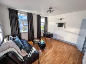 a living room with a couch and a tv at Shoreditch London - Lovely Two-Bedroom Apartment in London