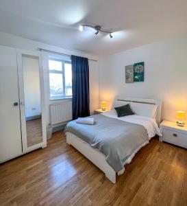 a bedroom with a large bed and a window at Shoreditch London - Lovely Two-Bedroom Apartment in London
