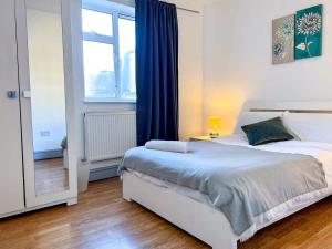 a bedroom with a large bed and a window at Shoreditch London - Lovely Two-Bedroom Apartment in London