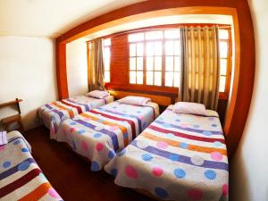 3 Betten in einem Zimmer mit Fenster in der Unterkunft HOSPEDAJE SCHASCA in Oxapampa