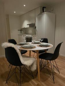 a dining room table with chairs and wine glasses at Cozy apartment with a view in Tromsø