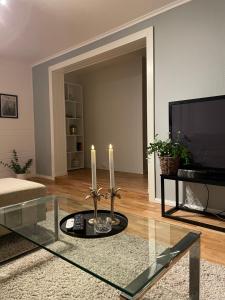 a living room with two candles on a glass table at Cozy apartment with a view in Tromsø
