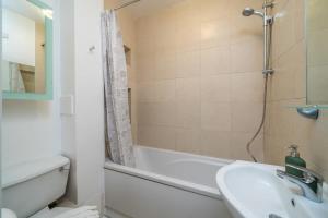 a bathroom with a sink and a tub and a shower at City of London Lovely Two Bedroom Apartment in London