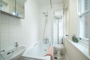 a white bathroom with a sink and a toilet at TruStay Apartments London Brick Lane in London