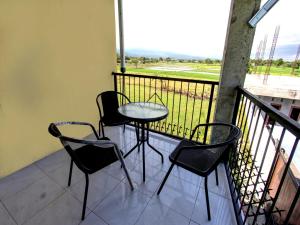 eine Terrasse mit 3 Stühlen und einem Tisch auf dem Balkon in der Unterkunft OYO Life 92769 Janigo Kos in Tanjungkarang