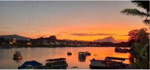 una puesta de sol sobre un puerto con barcos en el agua en Hotel Villa Guatape, en Guatapé