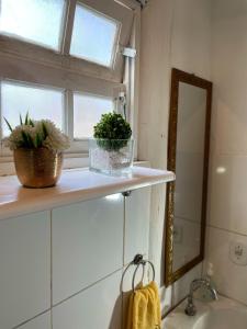 a bathroom with a sink and a window and a mirror at Hostel Caiçara Maresias in São Sebastião