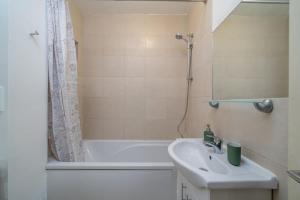 a bathroom with a sink and a bath tub at City of London - Lovely Two Bedroom Apartment in London