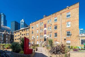 a large brick building in front of a city at City of London - Lovely Two Bedroom Apartment in London
