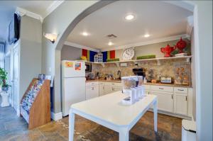 uma cozinha com uma mesa branca e um frigorífico branco em Scottish Inns Galveston em Galveston