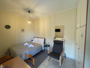 ein Hotelzimmer mit einem Bett und einem Stuhl in der Unterkunft Flo's Apartment in Mesolongi