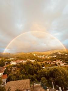 un arco iris en el cielo sobre una ciudad en Villa Solsticia, en Porticcio