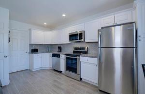 a kitchen with white cabinets and a stainless steel refrigerator at 37B- Casa Grande Condo full remodel w HEATED POOL in Casa Grande