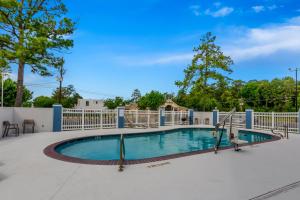 a swimming pool on a patio with a fence at Comfort Inn Conroe in Conroe
