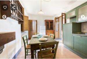 uma cozinha com uma mesa de madeira com cadeiras e uma mesa; em Villa del Giardo em Lido di Camaiore
