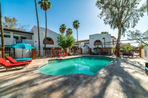 uma piscina com cadeiras e um edifício em 78- Modern Casa Grande Desert Paradise heated pool em Casa Grande