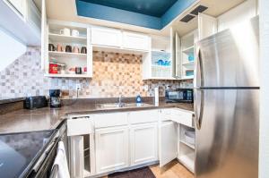 uma cozinha com armários brancos e um frigorífico de aço inoxidável em 78- Modern Casa Grande Desert Paradise heated pool em Casa Grande