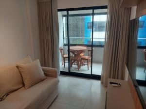 uma sala de estar com um sofá e uma mesa em Apartamento Novo em Ondina em Salvador
