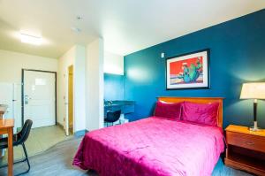 um quarto com uma cama rosa e uma parede azul em Sierra Vista studio apartment with full kitchen and King Bed em Sierra Vista
