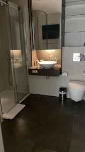 a bathroom with a sink and a shower and a toilet at Modern apartment w/ canal view in London