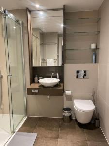 a bathroom with a toilet and a sink and a shower at Modern apartment w/ canal view in London