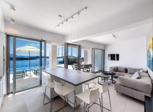 a dining room and living room with a table and chairs at Apaggio Villas in Nydri