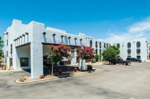 a large white building with flowers in a parking lot at Vistas 216- Renovated central Sierra Vista long term discounts in Sierra Vista