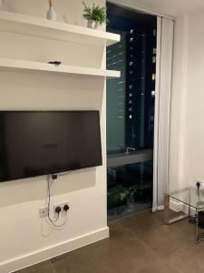 a living room with a flat screen tv on a wall at Modern apartment w/ canal view in London