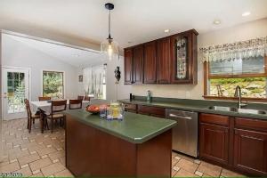 a kitchen with wooden cabinets and a dining room at Large Private House on 5 Wooded Acres. Total Privacy! in Hackettstown