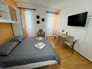 a bedroom with a bed and a desk and a flat screen tv at Apartment Marija in Vodnjan