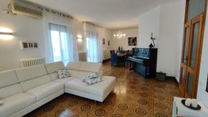 a living room with a white couch and a piano at La Residenza del Cavallino in Fermo