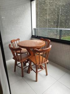 uma mesa e duas cadeiras e uma mesa e uma janela em Apartamento Novo em Ondina em Salvador