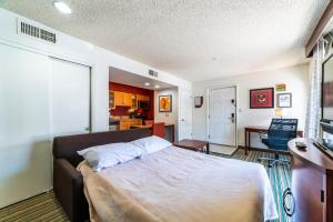 1 dormitorio con 1 cama grande y cocina en Metro PHX Promotional Studio, en Phoenix
