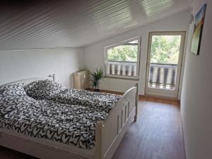 - une chambre avec un lit et 2 fenêtres dans l'établissement Wohnung auf dem Pferdehof, à Mahlberg