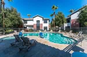 a swimming pool with chairs and a house at Chandler Promo 1bd 1ba in Chandler