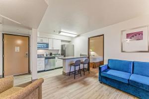 a living room with a blue couch and a kitchen at Chandler Promo 1bd 1ba in Chandler