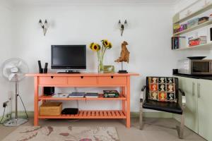 an orange desk with a television on top of it at Stylish Apartment with Private Rooftop in Covent Garden in London