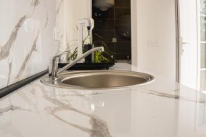 a sink in a bathroom with a marble counter top at Fox Apartment in Gevgelija