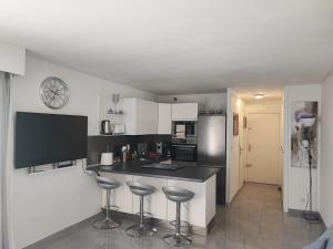 a kitchen with a black counter and stools in it at Studio Cap d'Agde in Cap d'Agde