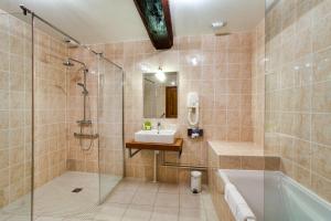 ein Badezimmer mit einer Dusche, einer Badewanne und einem Waschbecken in der Unterkunft Hotel Belle Epoque in Beaune