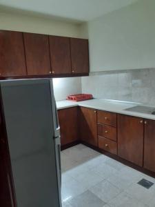 a kitchen with wooden cabinets and a refrigerator at The Hotel and Apartment At Times Square in Kuala Lumpur