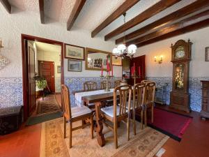 ein Esszimmer mit einem Tisch und einer Großvater-Uhr in der Unterkunft Casa d'Além - Gerês in Terras de Bouro + 39 Fotos