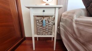 a white table next to a bed next to a bed at Apartamento 1 dormitorio 4 personas en El Grove in O Grove