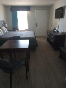a hotel room with a bed and a desk and a television at RELAX INN in Rockingham